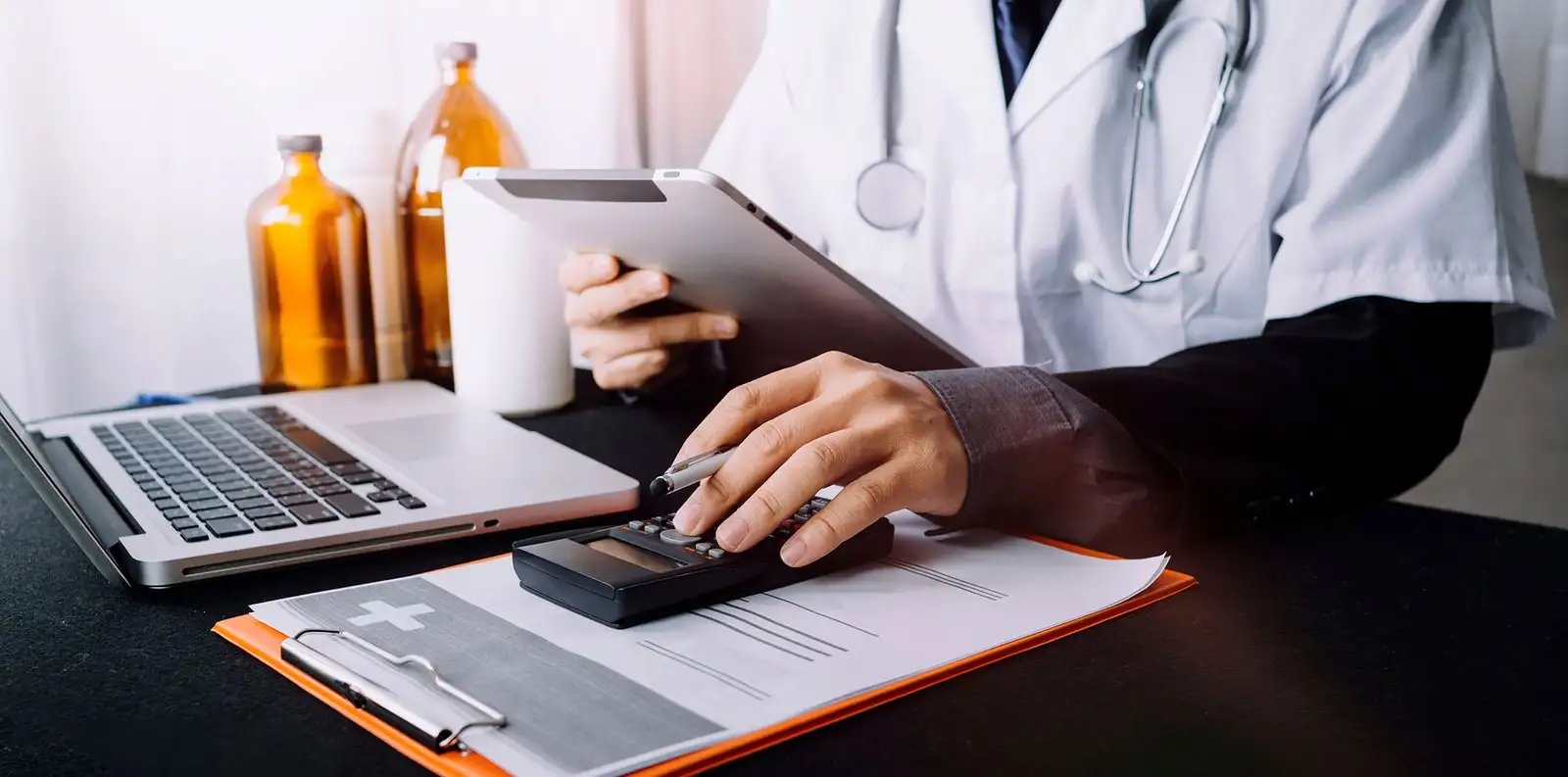A doctor uses a tablet and pen, focused on digital notes in a clinical setting.